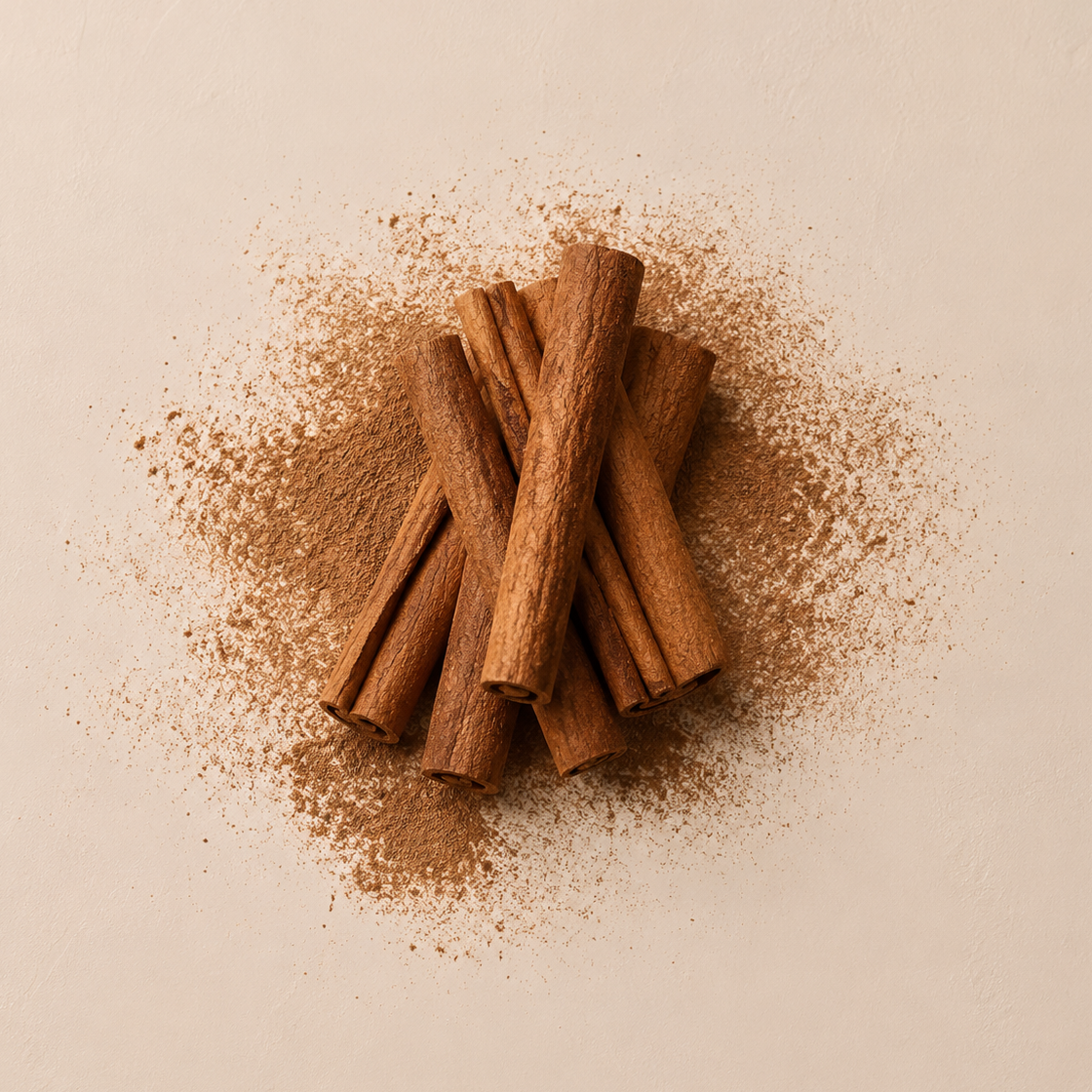 A small pile of whole cinnamon sticks with scattered cinnamon powder on a warm beige background. Image
